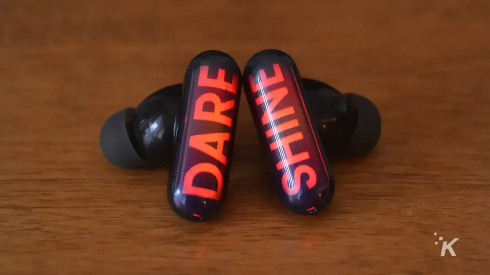 Наушники GPods со словом Dare Shine на деревянном столе