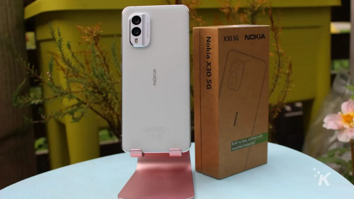 Телефон Nokia X30 на подставке рядом с коробкой