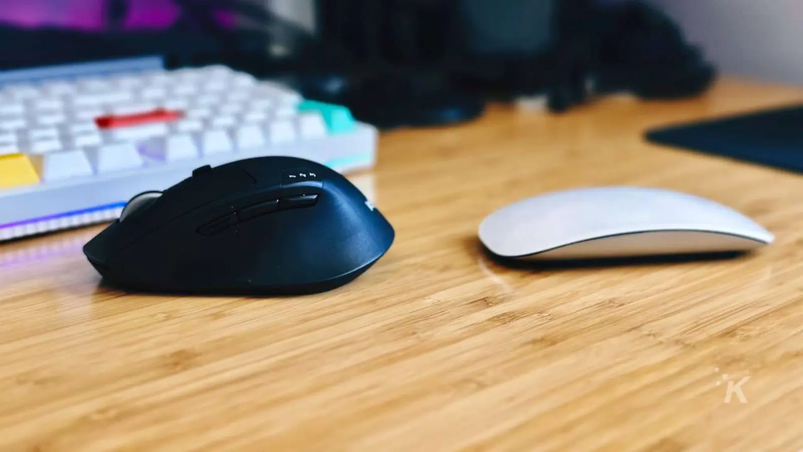 imagen de lado a lado del mouse mágico de apple frente al mouse logitech m720 en el escritorio de la oficina