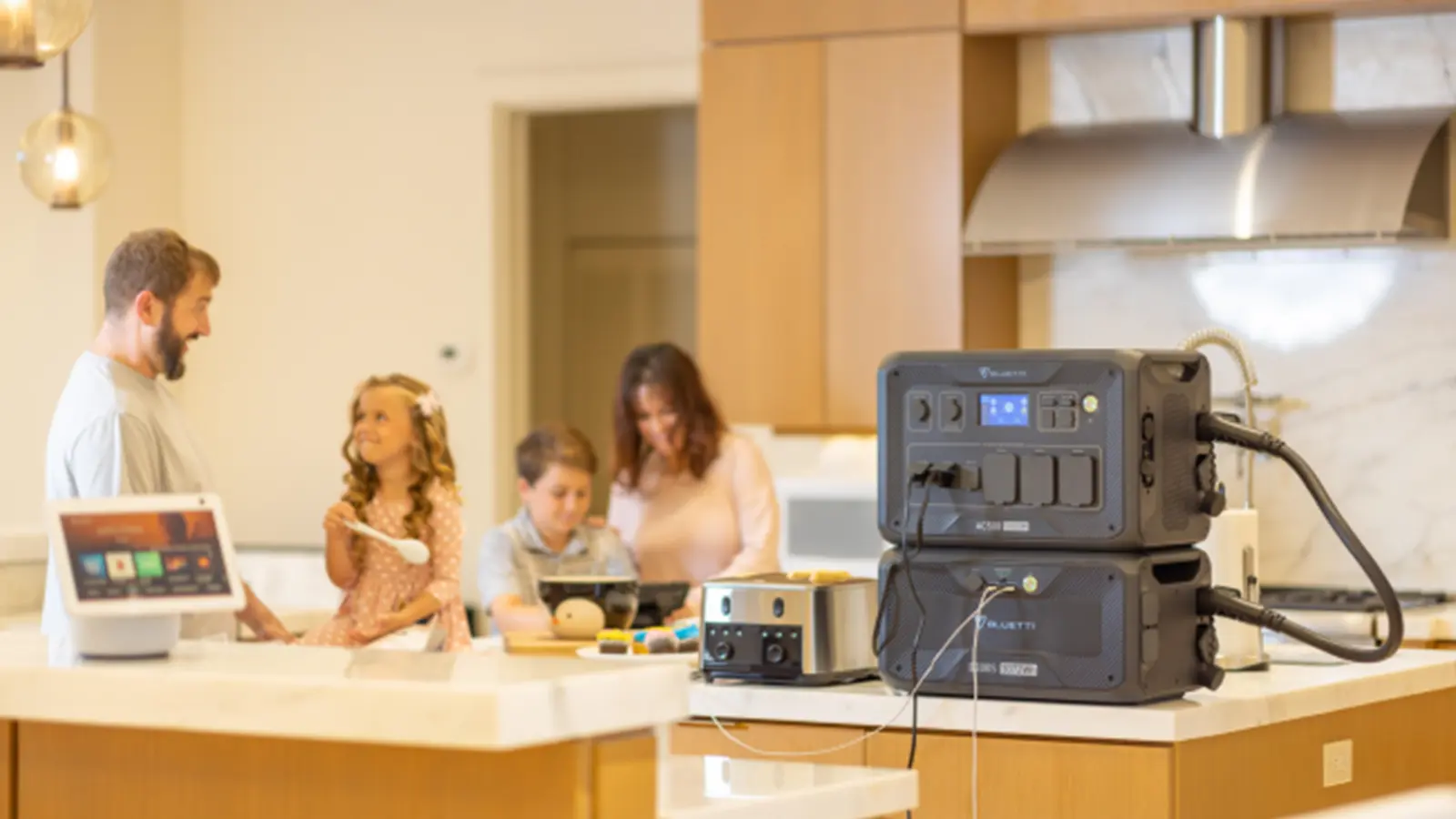 Família reunida na cozinha ao lado de uma unidade de armazenamento de energia BLUETTI.