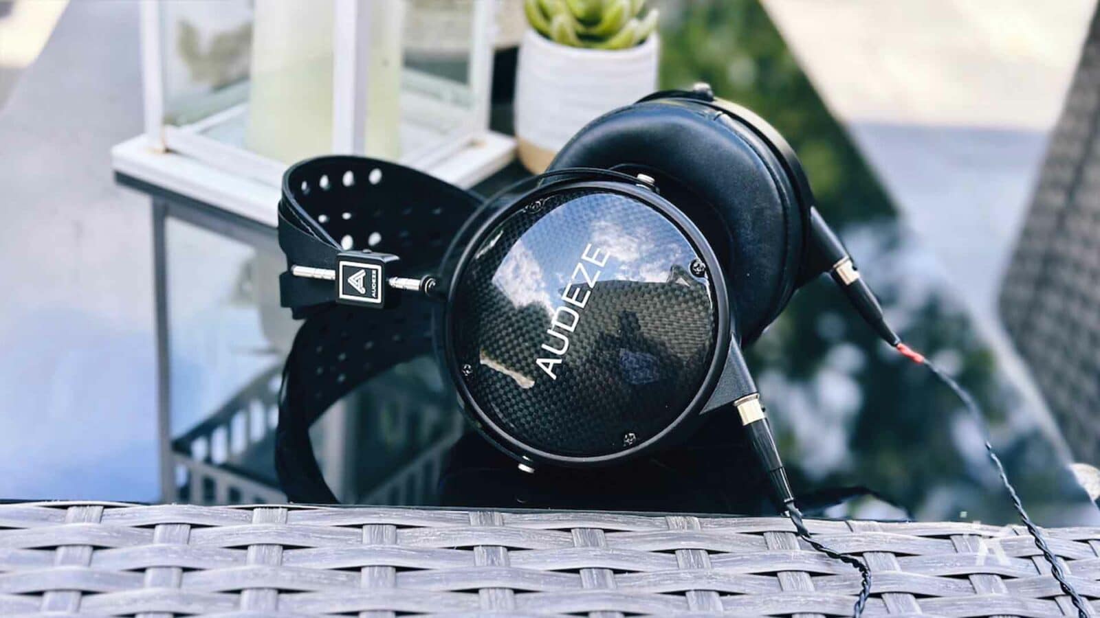 Um ventilador mecânico está girando na frente de um prédio ao ar livre, com um medidor de fones de ouvido AUDEZE