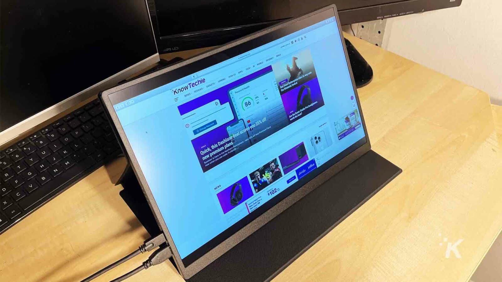 UPERFECT-monitor portabil pe un birou cu site-ul web KnowTechie pe ecran