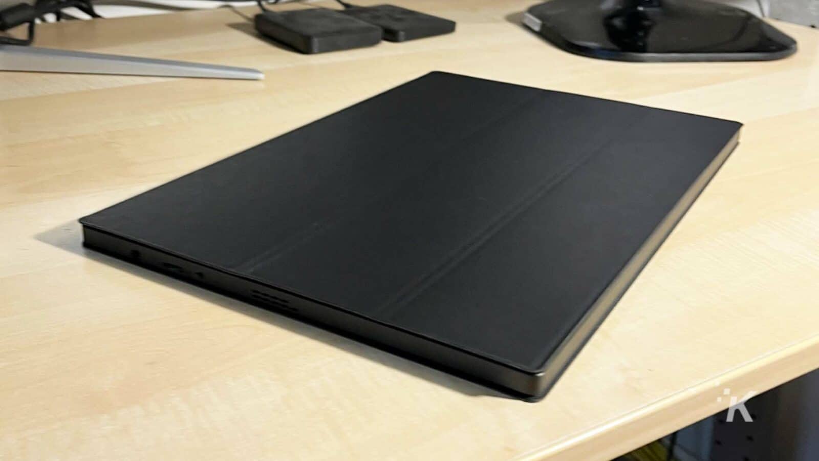 UPERFECT-monitor portabil pe un birou cu capacul pus.