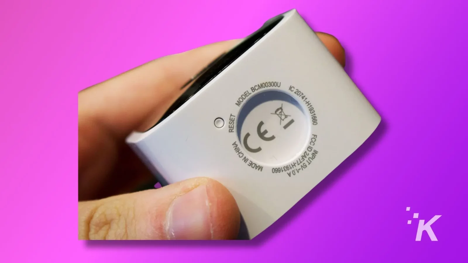 깜박임 카메라 재설정을 수행하는 방법 11 A person holding a blink mini camera in a hand showing reset button on blink mini