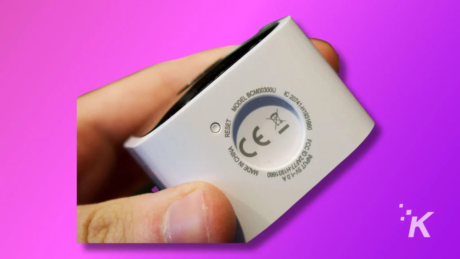 masalah wi-fi kamera berkedip - perbaikan cepat Person holding a blink camera in hand showing reset button on blink