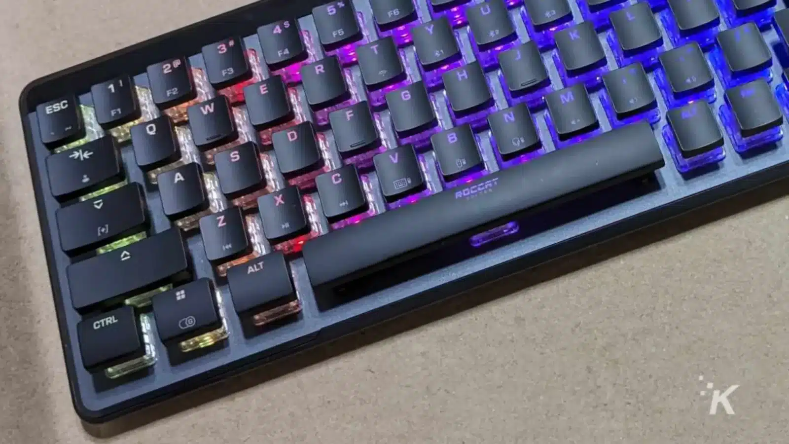 评测:roccat vulcan ii 迷你空气机械键盘 A purple computer keyboard with various levers and buttons is connected to a computer component to provide input.