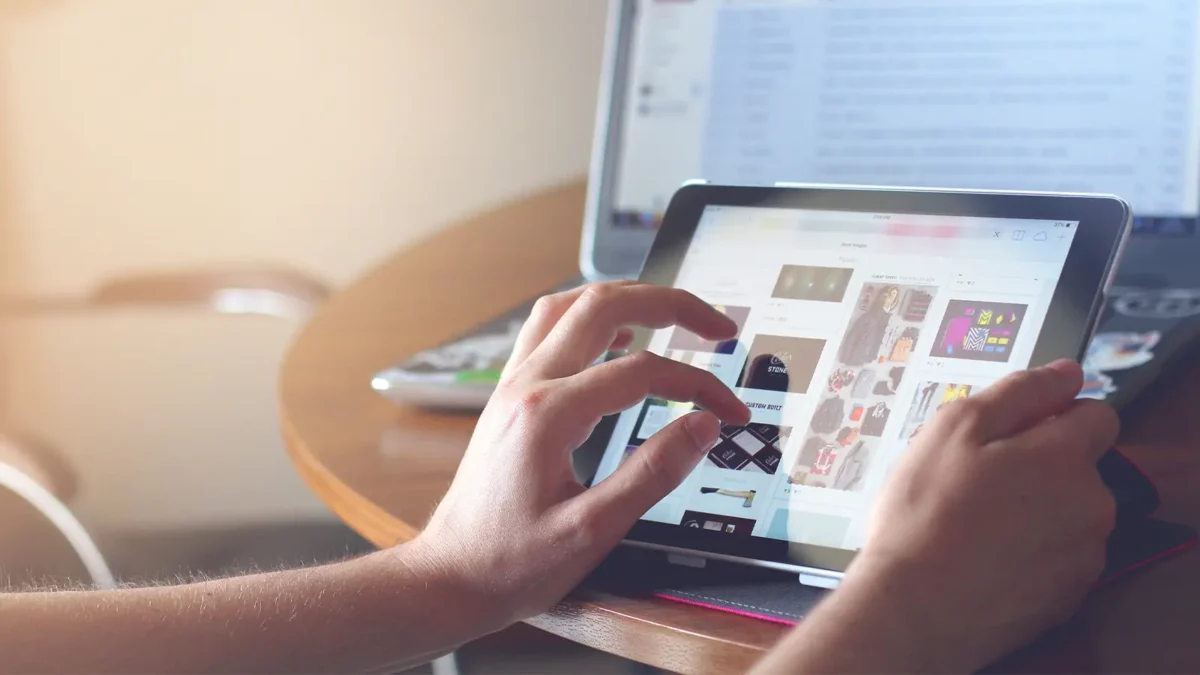 e-ticarette ai: gelişmeler ve yenilikler Person on tablet setting up an ecommerce store