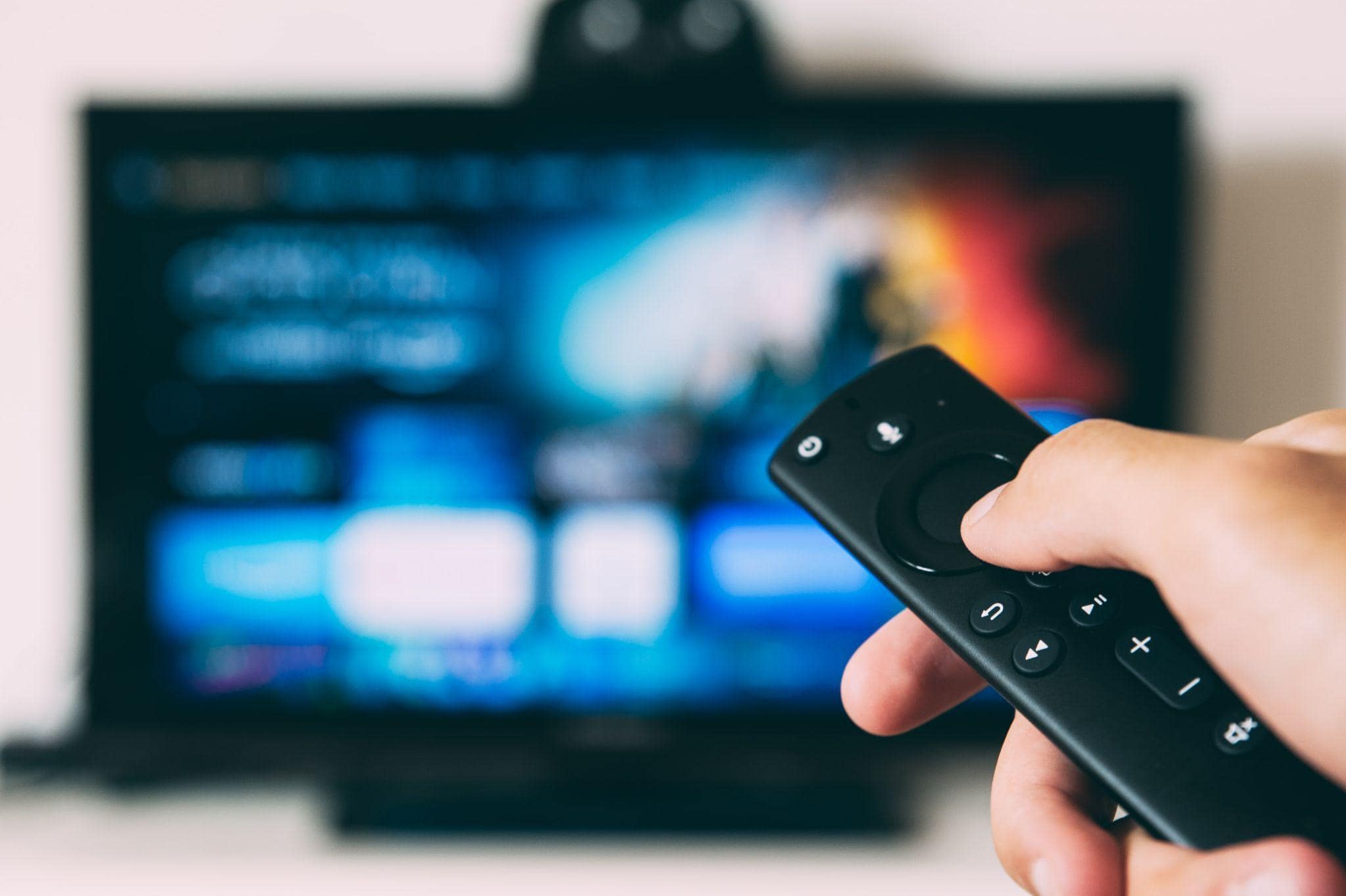 Un control remoto apuntando a la pantalla de un televisor.