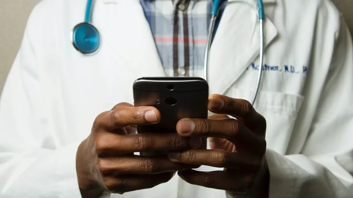 L'avenir de l'IA - 6 façons dont l'IA se développe rapidement Healthcare worker looking at his phone app
