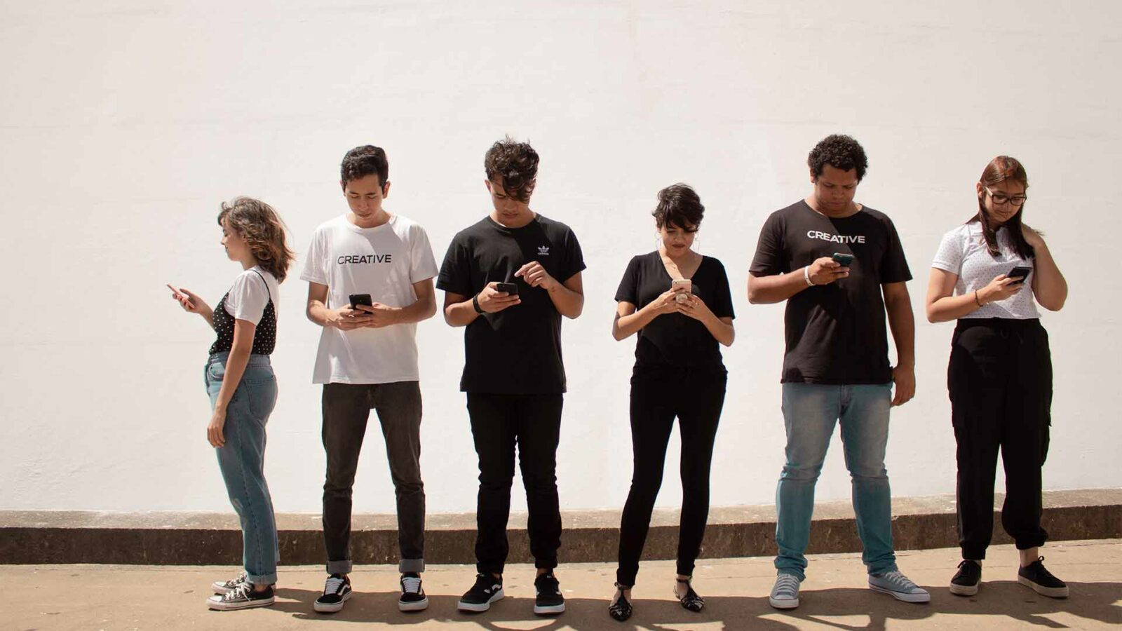 Sekelompok remaja berdiri melihat telepon