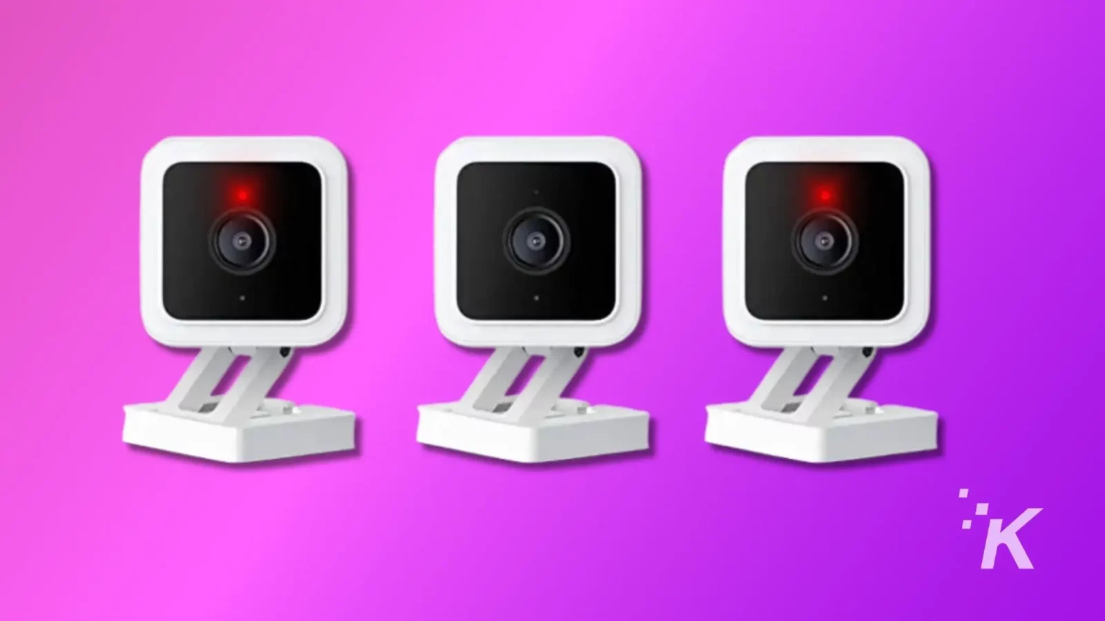 wyze 在再次出现相机安全问题后道歉 Three similar white webcams with red recording lights, mounted on adjustable stands, presented against a gradient purple background with a watermark.
