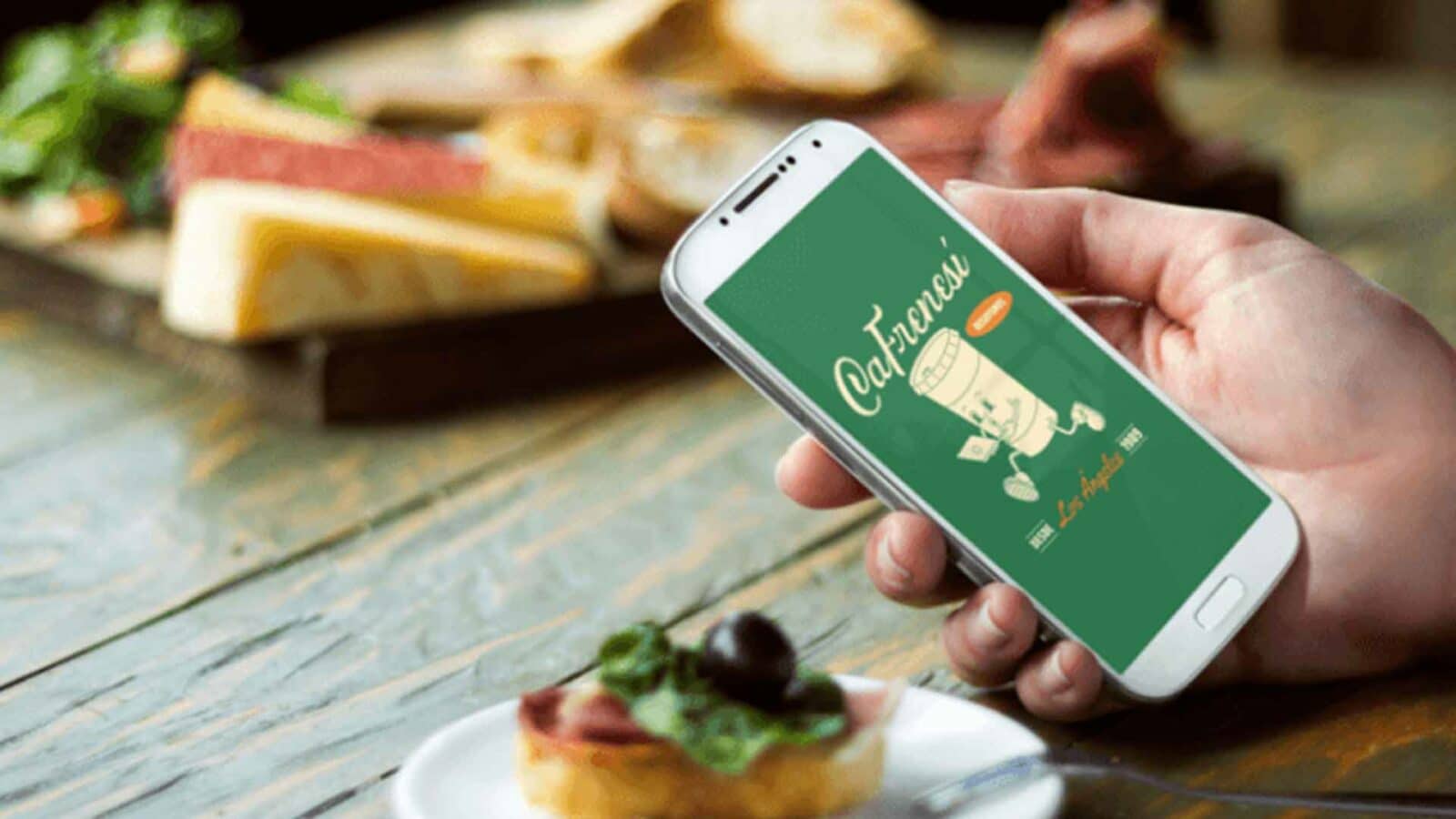 Logo of a company on a phone screen with a sandwich in the background