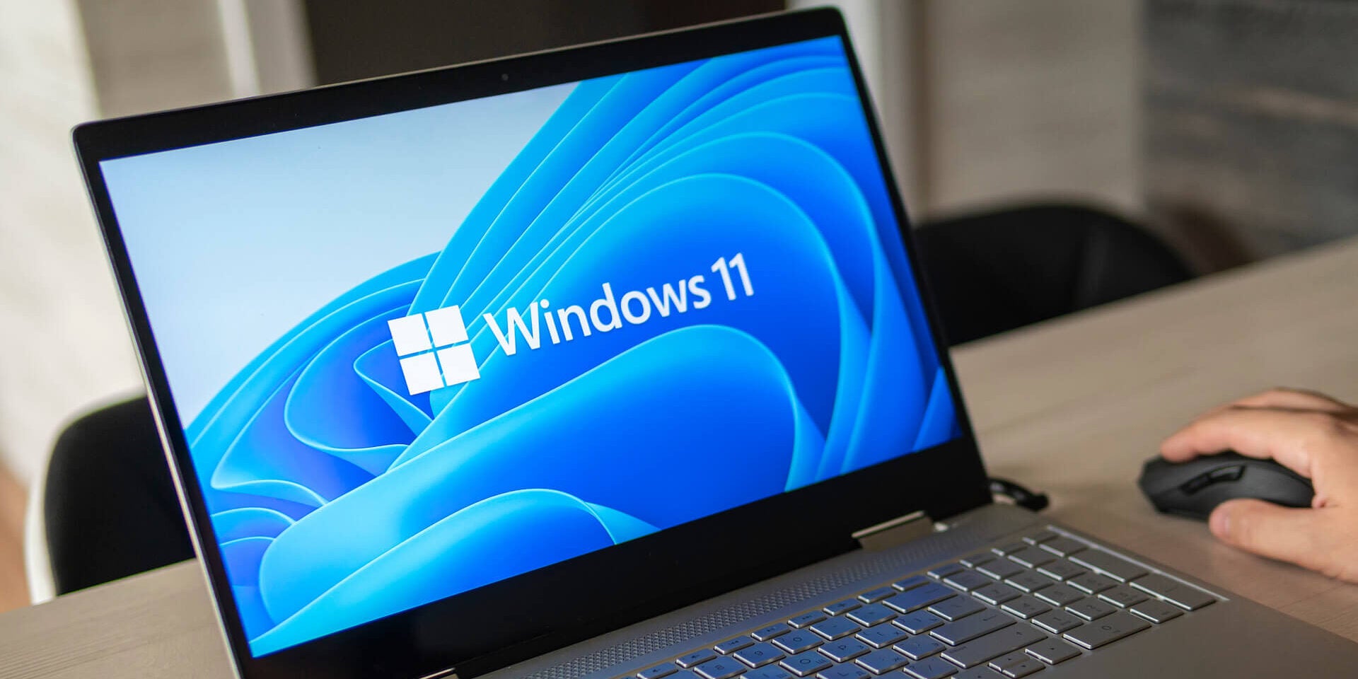 Logo systemu Microsoft Windows 11 działające na ekranie laptopa używane w pracy