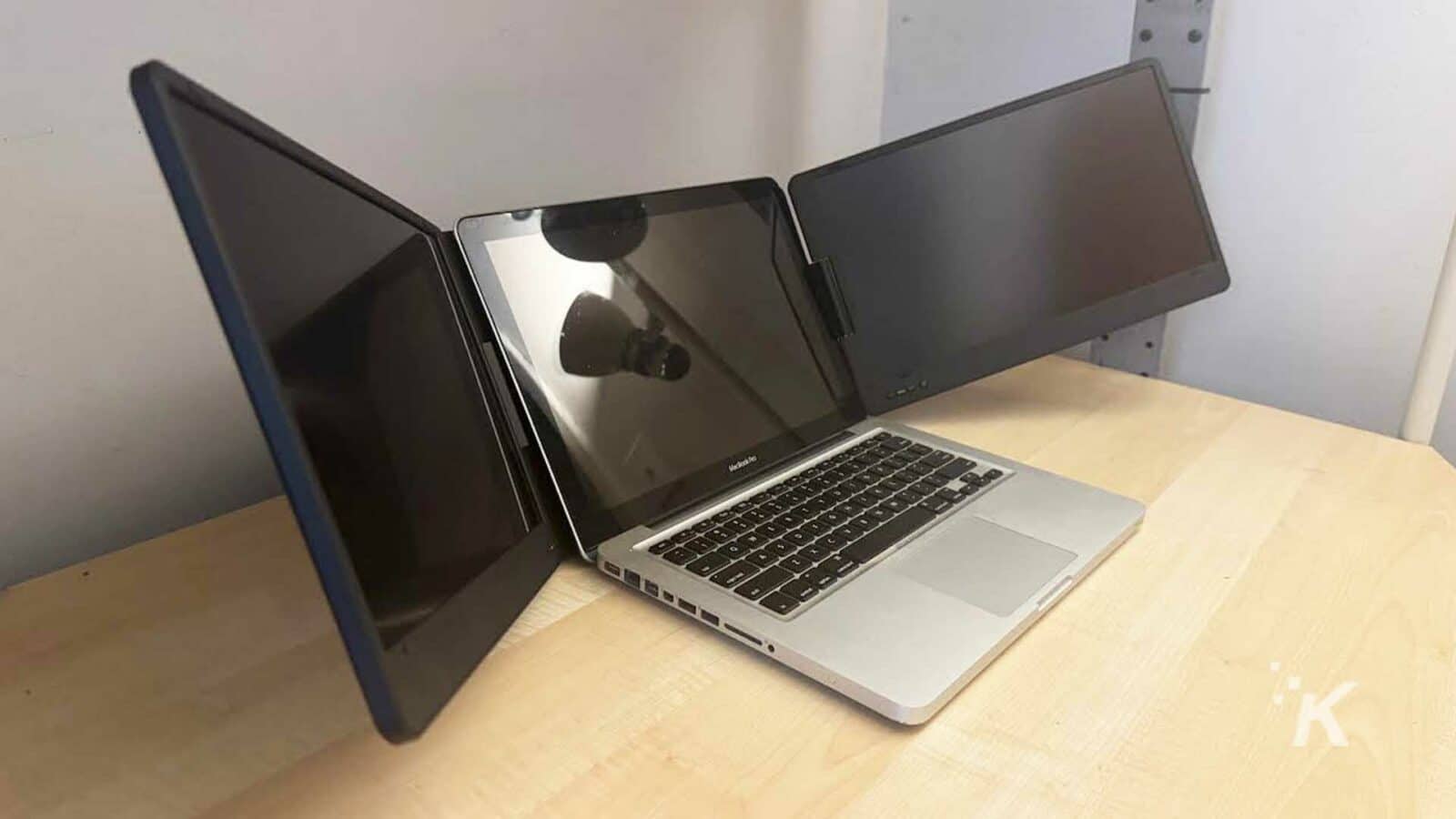 tingkatkan produktivitas dengan perluasan tiga layar laptop qqh The qqh triple laptop screen extender with a laptop on a desk.