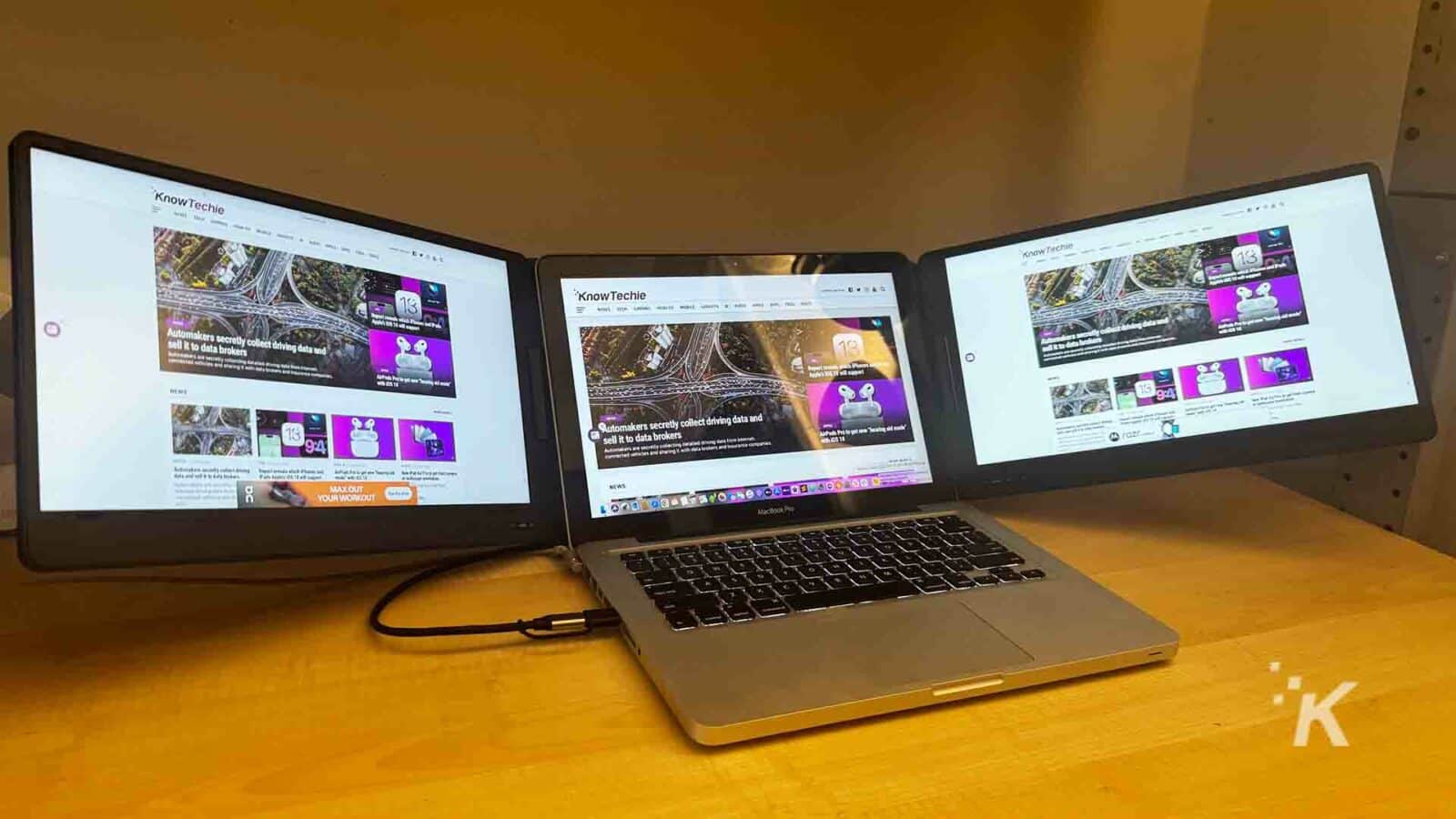 tingkatkan produktivitas dengan perluasan tiga layar laptop qqh The qqh triple laptop screen extender with a laptop on a desk.