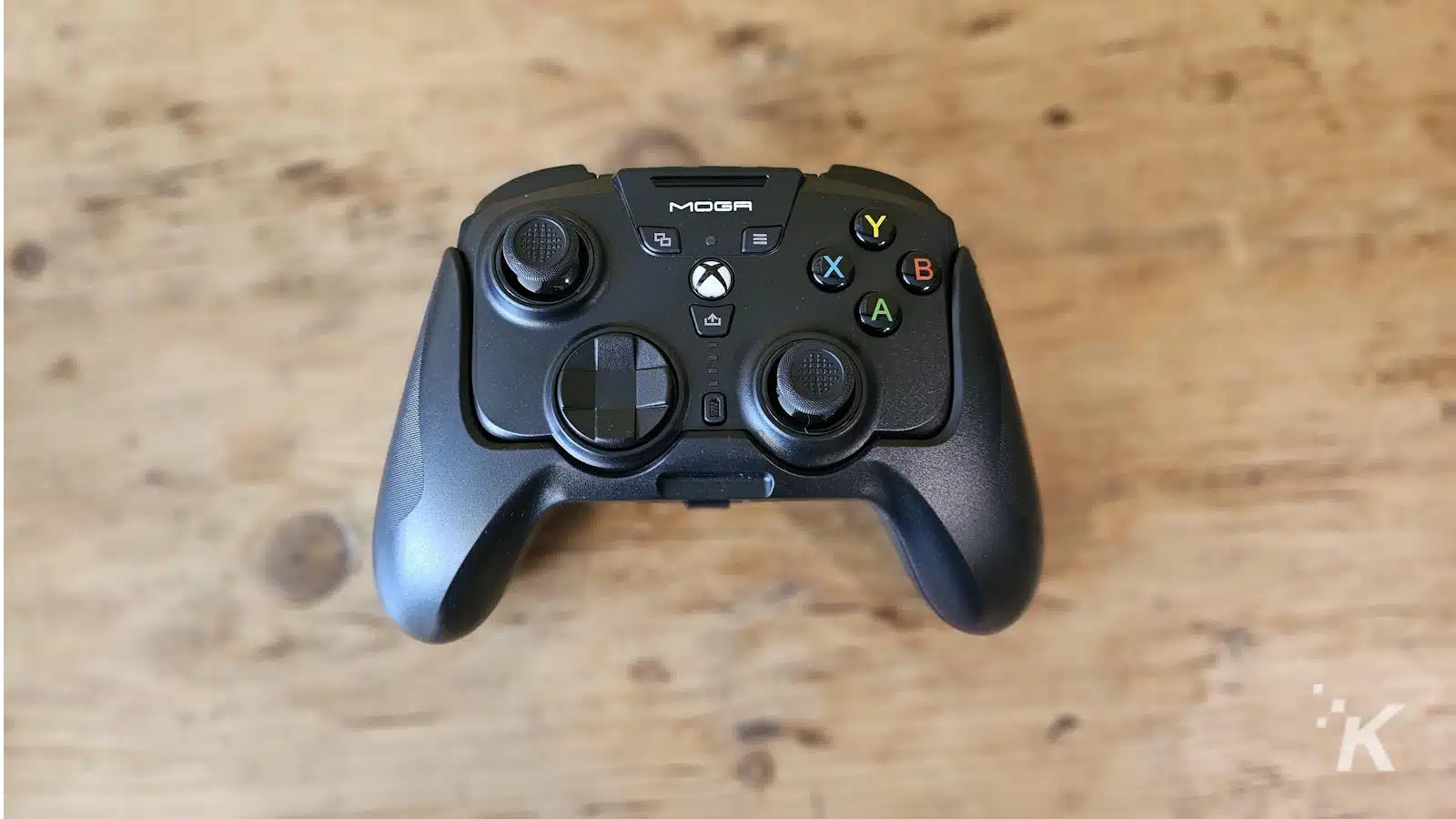 Controler de jocuri Xbox MOGA pe masă de lemn.