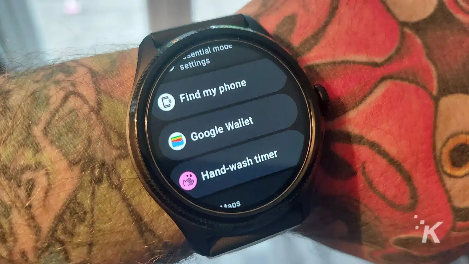 タトゥーのある手首に Google ウォレットとアプリを表示するスマートウォッチ。