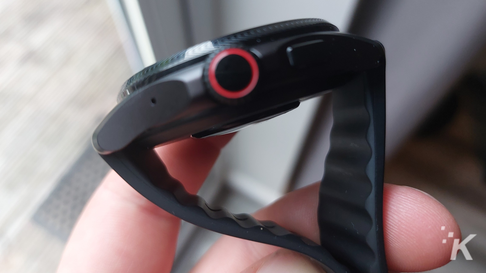黒いバンドと赤いボタンを備えたスマートウォッチの側面図