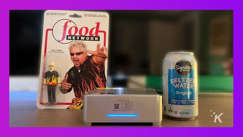 كمبيوتر KAMRUI الصغير في الصورة مع علبة من المياه الغازية ولعبة Guy Fieri.