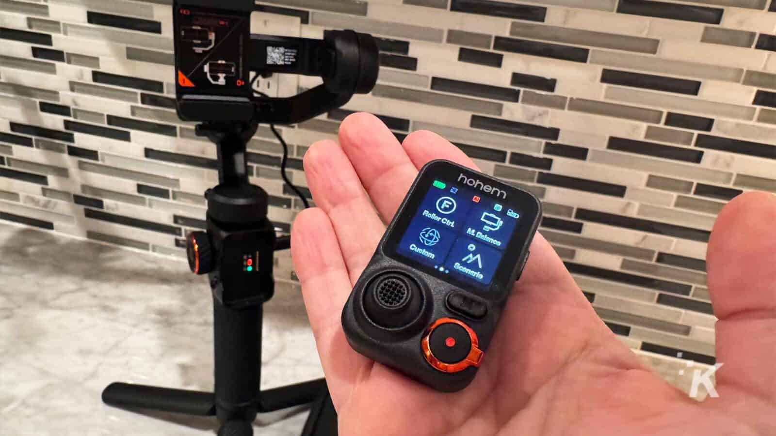 Mano sosteniendo el control remoto del cardán Hohem iSteady M7.