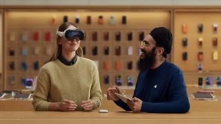 พนักงานของ Apple Store แสดงให้ลูกค้าเห็นถึงวิธีใช้ชุดหูฟัง Vision Pro