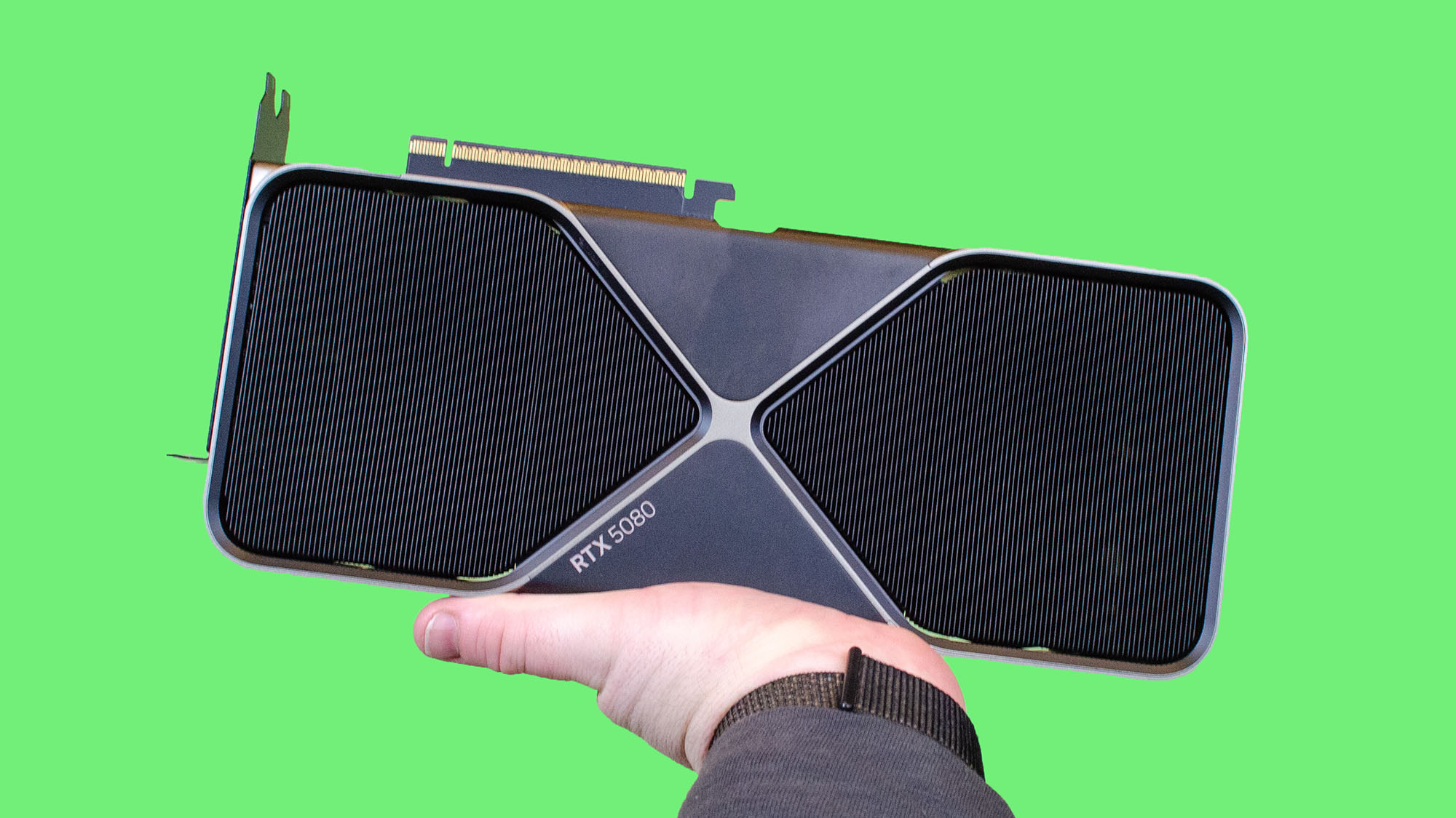 男性手拿着Nvidia geforce RTX 5080在绿色背景下