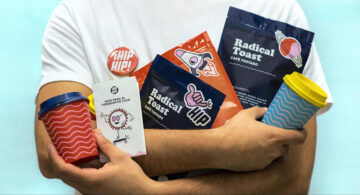 Person holding branded coffee packaging, cups, booklet, and badge showcasing a cohesive brand strategy