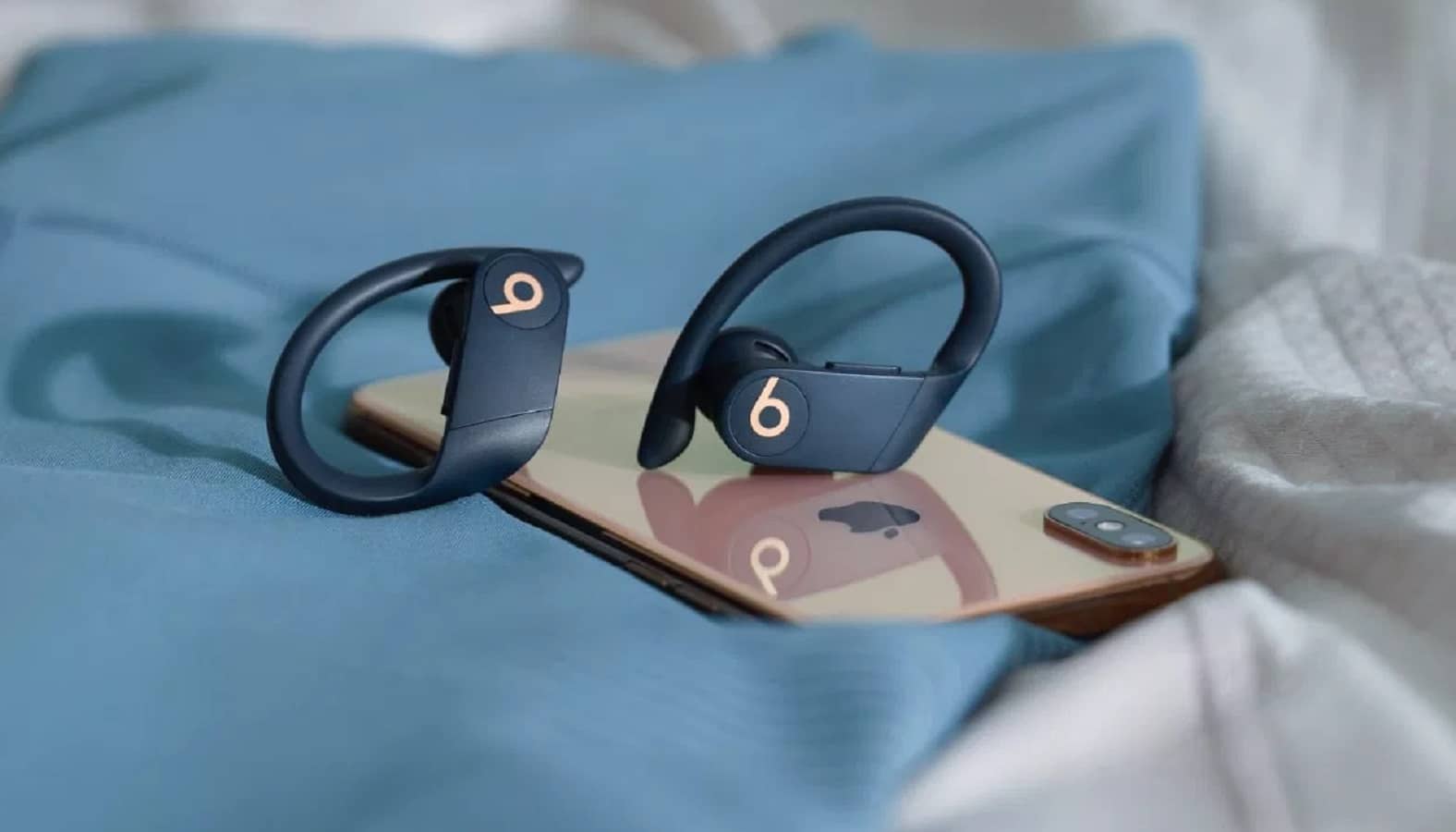 powerbeats pro iphone üzerinde oturan kablosuz kulaklıkları yener