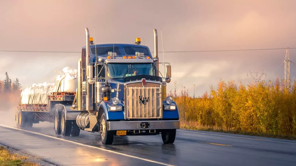 semi-camion care conduce pe drum în ploaie