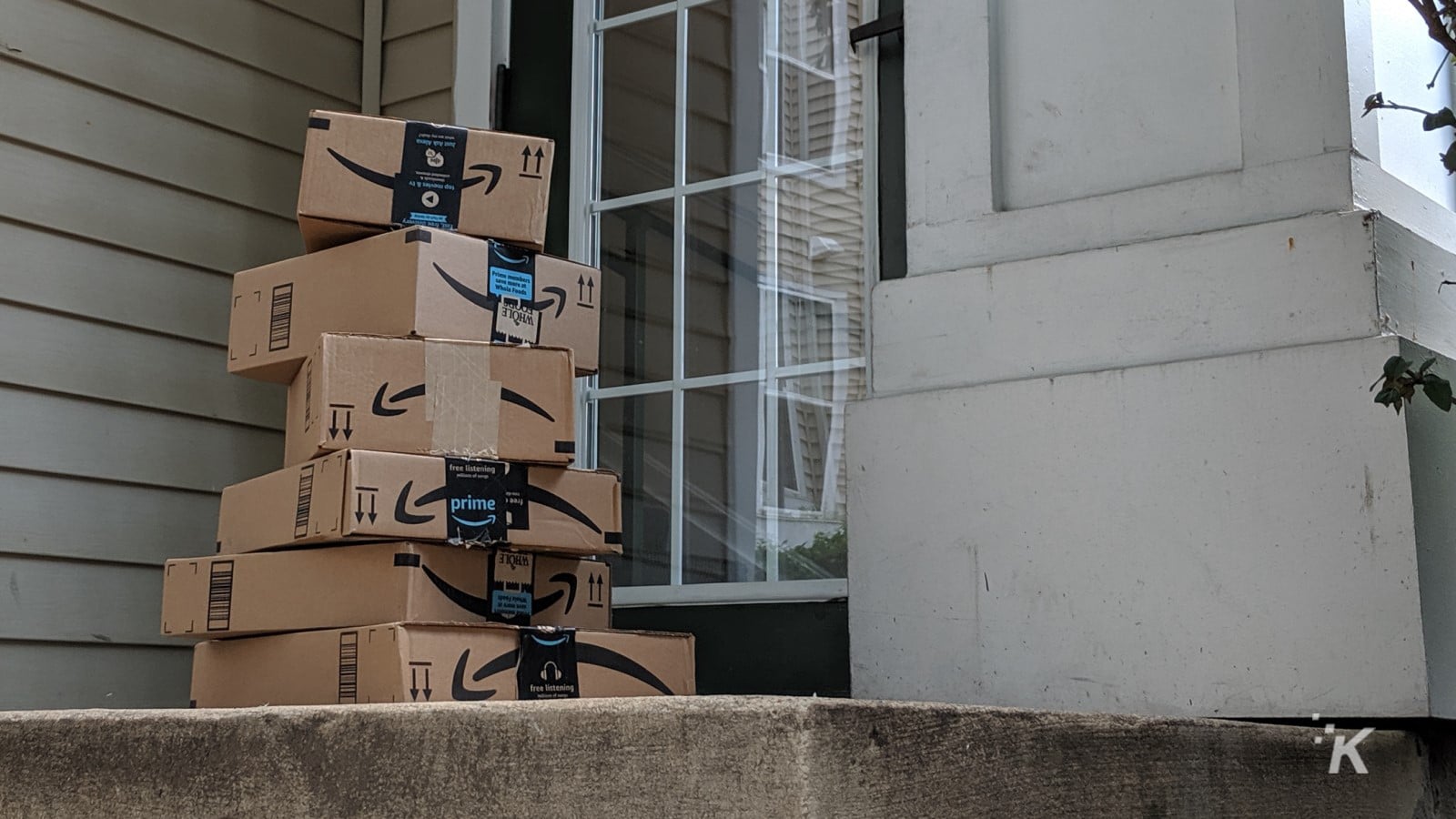 bir verandada yığılmış amazon teslimat kutuları