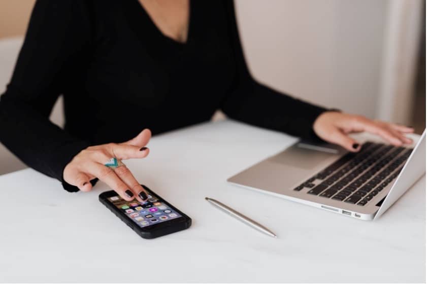 Die häufigsten Probleme mit Smart-Home-Technologiesystemen 4 A person with a phone and a laptop.